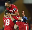 Quade Cooper celebrates with his Reds team-mates following their 18-13 win over the Crusaders