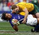 Samoa's Maurie Fa'asavalu is tackled by Australia's Pat McCabe