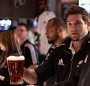 Cory Jane of the All Blacks admires his beer pouring skills
