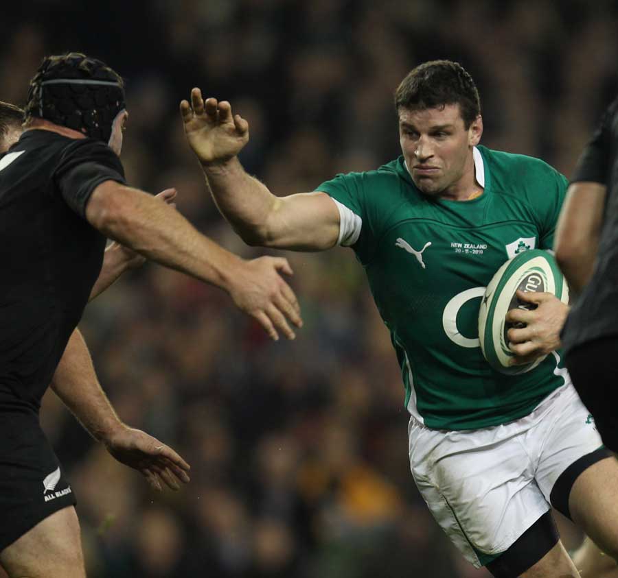 Denis Leamy tries to force his way through the New Zealand defence