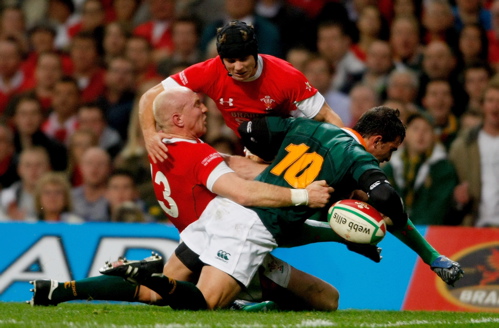 Wales players Tom Shanklin and Leigh Halfpenny combine to stop Ruan Pienaar of South Africa
