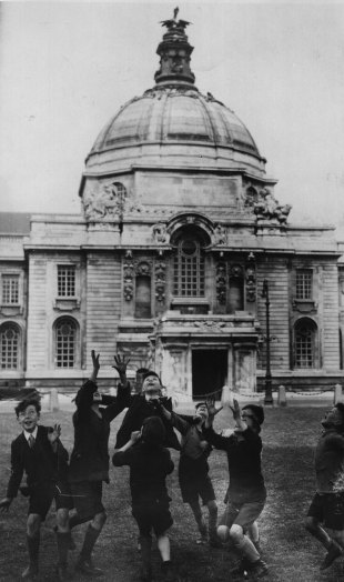 A group of boys play rugby by Cardiff City Hall, Cardiff, Wales, May 27, 1935