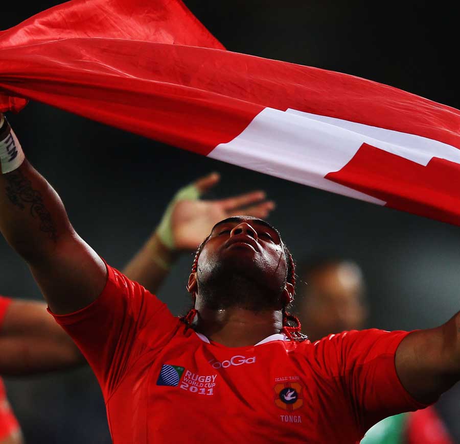 Tonga's Taneila Moa holds aloft the Tongan flag after they impress in the World Cup opener