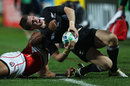 All Blacks fly-half Colin Slade is tackled into touch