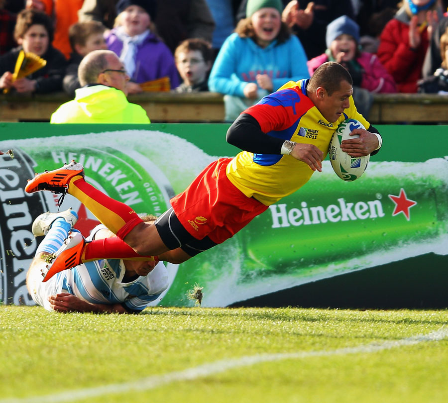 Romania's Iionel Cazan dives over to score a try