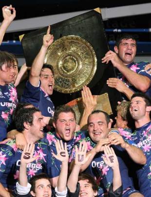 Stade Francais players celebrate with the "Bouclier de Brennus" after defeating Clermont Auvergne in the Top 14 final at the Stade de France, June 9 2007