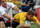 Australia's Drew Mitchell escapes the grasp of his opponent to crash over