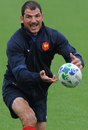 France's head coach Marc Lievremont passes the ball during training