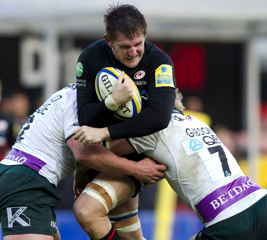 Saracens' Ernst Joubert is wrapped up by the London Irish defence