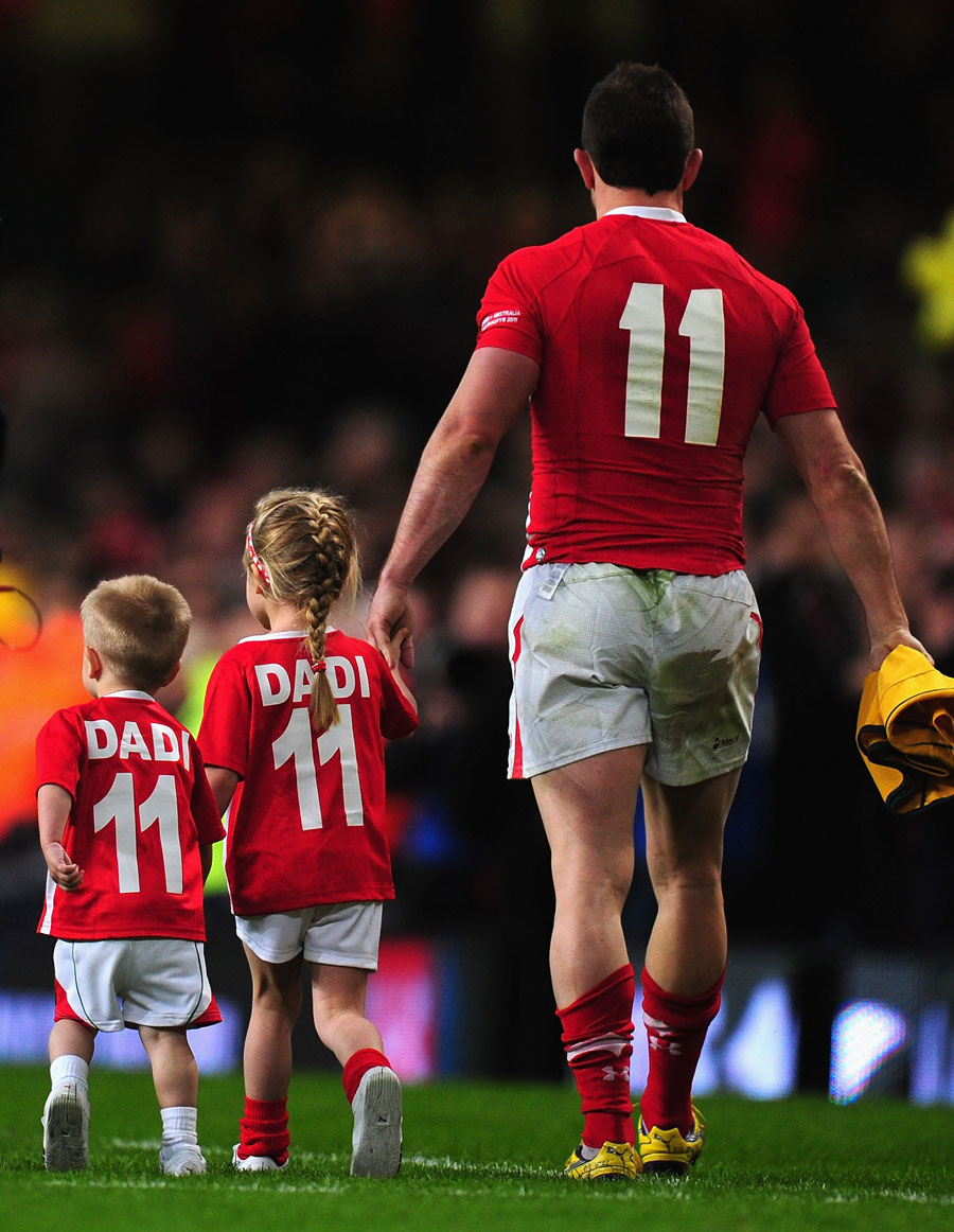 Wales' Shane Williams takes a lap of honour with his children