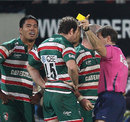 Referee Alain Rolland brandishes yellow cards to Leicester duo Manu Tuilagi and George Chuter