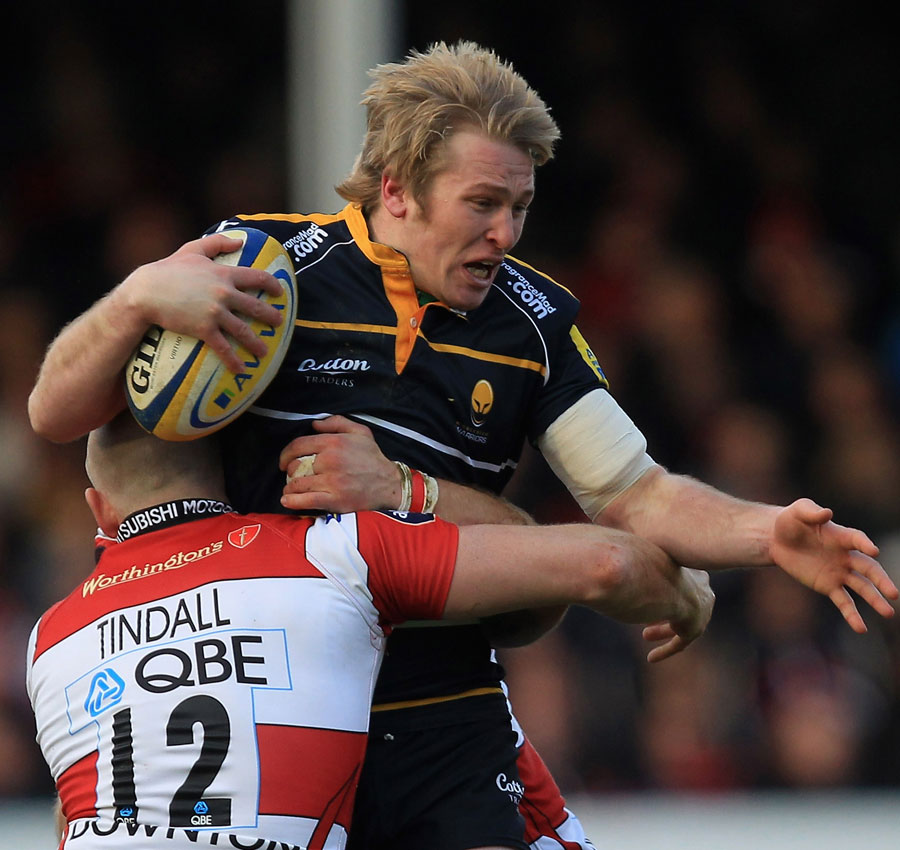 Worcester's Joe Carlisle is held up by Gloucester's Mike Tindall