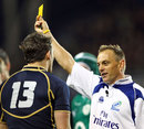 Referee Chris Pollack shows Scotland's Max Evans a yellow card