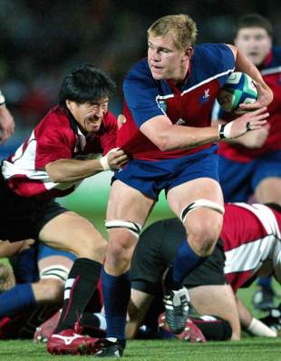 Japanese fullback Tsutomu Matsuda tackles flanker Kort Schubert of the USA during their Pool B Rugby World Cup 2003 match in Gosford stadium, on October 27, 2003