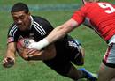 New Zealand's Ardie Savea dives under a tackle to score