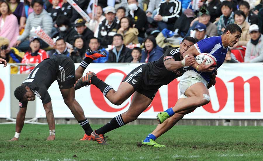 Samoa's Afa Alono charges through two New Zealand tackles