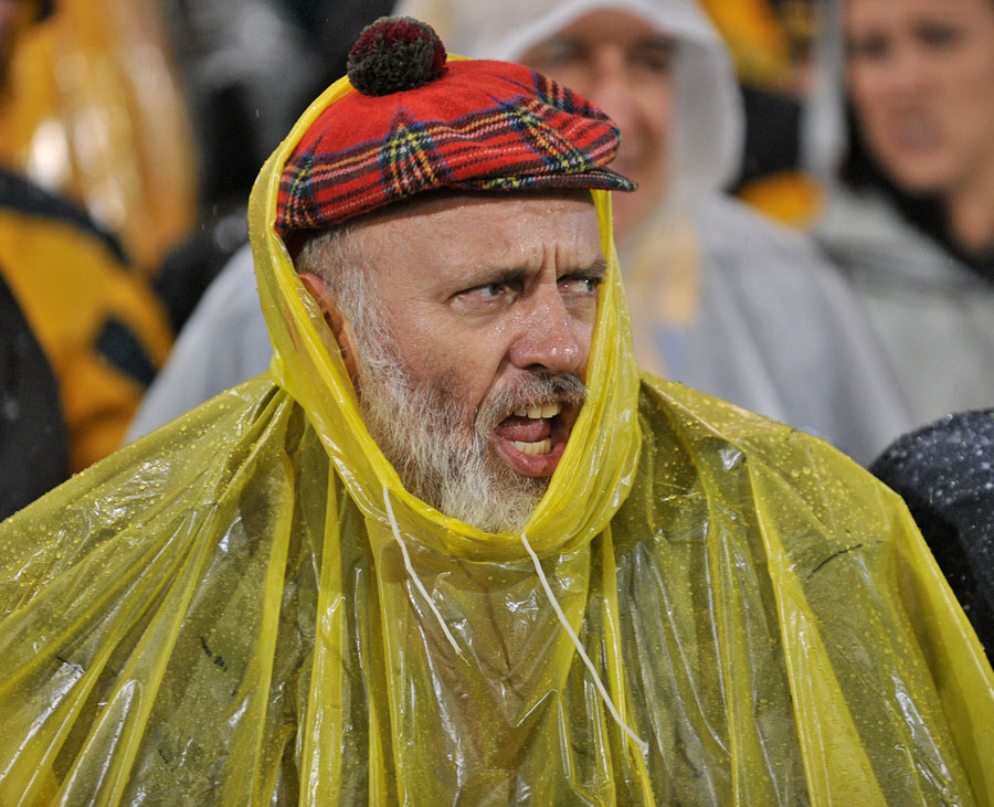 A Scotland fans shelters from the elements at the Hunter Stadium