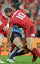 The Reds' Quade Cooper tackles the Waratahs' Berrick Barnes