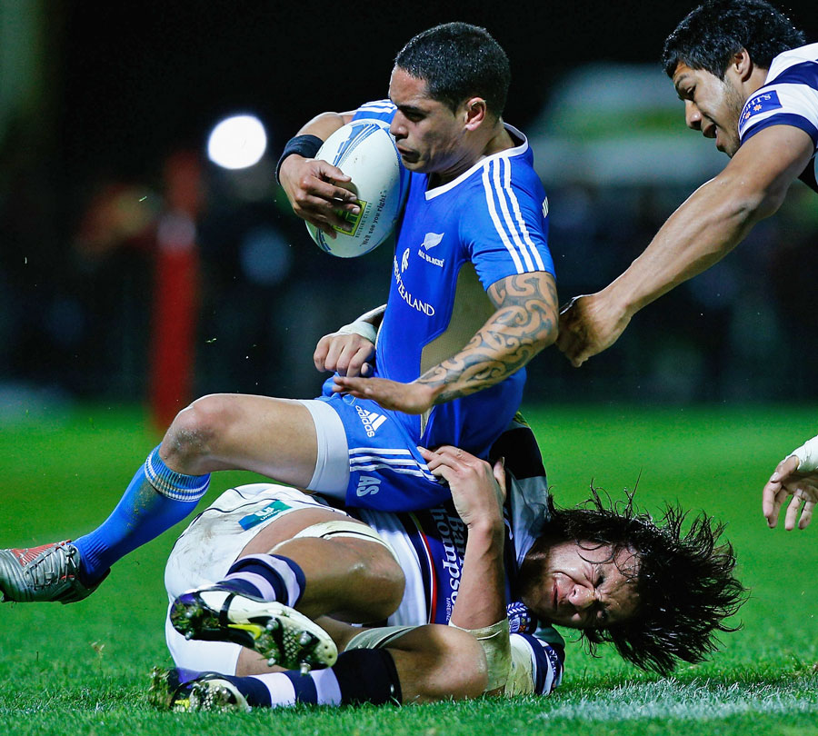 New Zealand's Aaron Smith is tackled by Auckland's Steven Luatua 