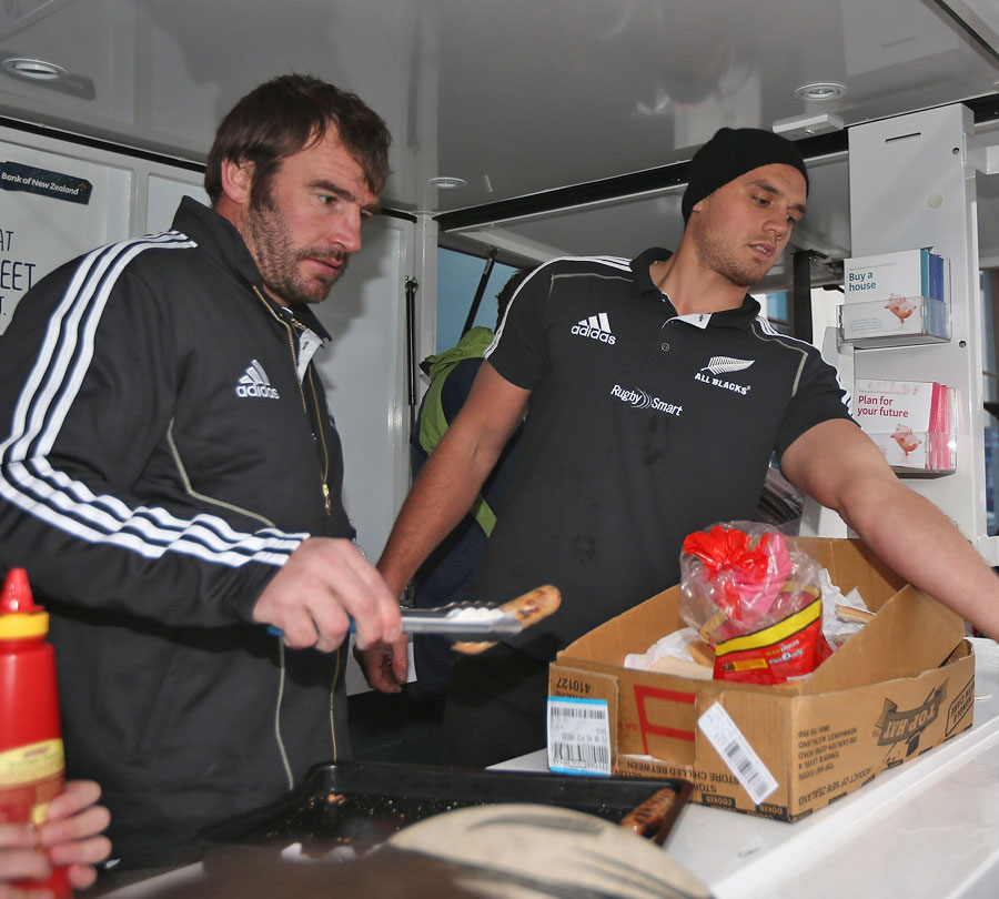 New Zealand's Andrew Hore and Israel Dagg serve food to fans