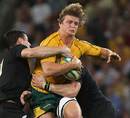 Australia's Nick Cummins is tackled by two All Blacks
