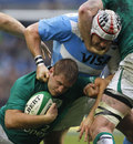 Ireland's Chris Henry is wrapped up by an Argentine defender