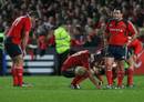 Munster are dejected after a narrow loss to New Zealand