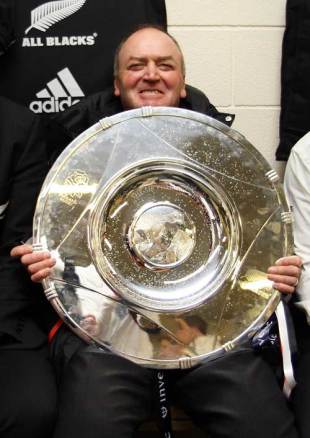 New Zealand Head Coach Graham Henry (C) poses the Hillary Shield in the changing rooms after the match between England and New Zealand at Twickenham in London, England on November 29, 2008.