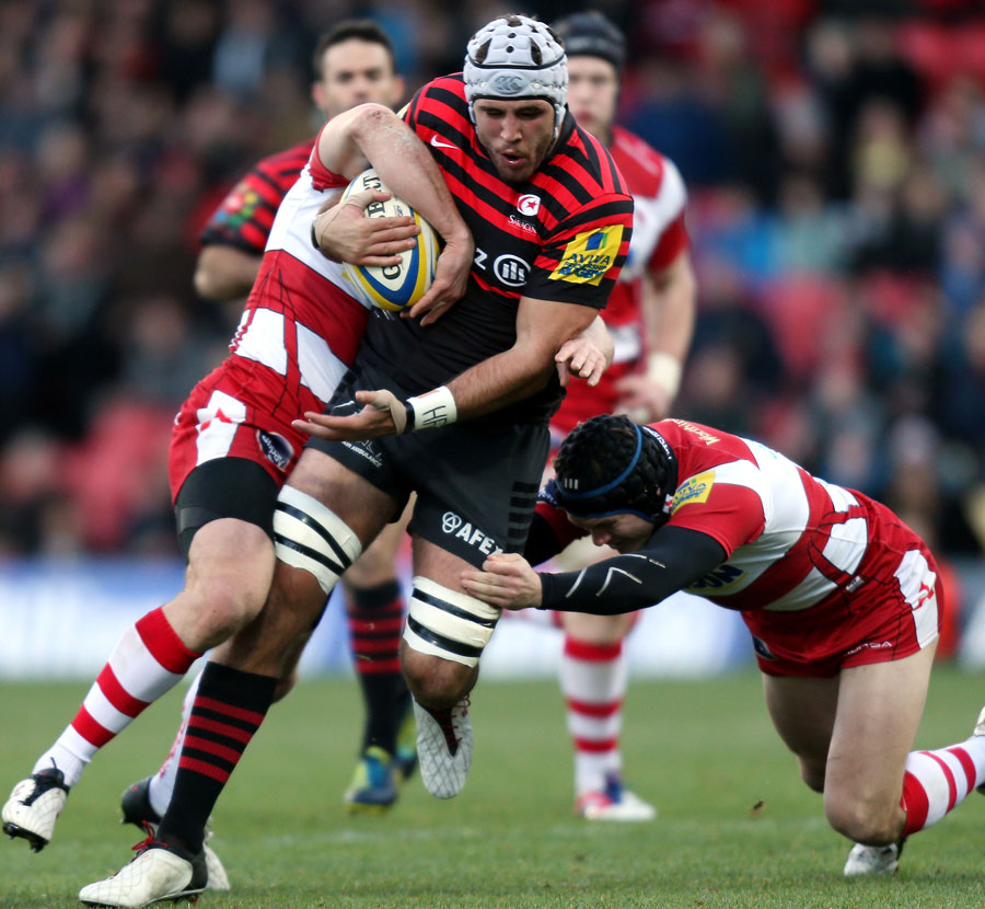 Saracens' Will Fraser is tackled by Gloucester's Mike Tindall and Rob Cook
