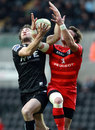 Ospreys' Andrew Bishop (left) and Toulouse's Maxime Medard challenge for a high ball 