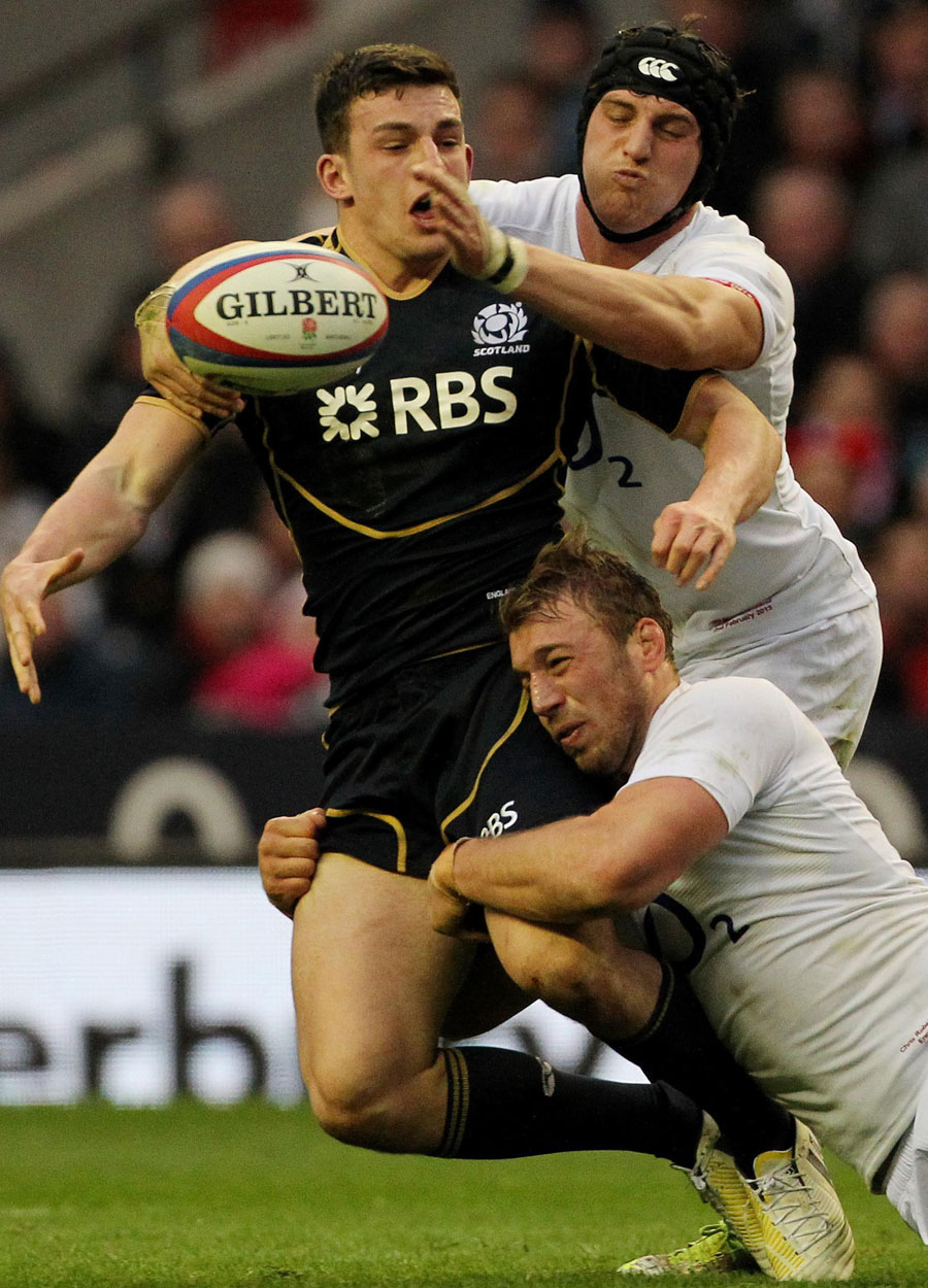 Scotland's Matt Scott is wrapped up by the England defence