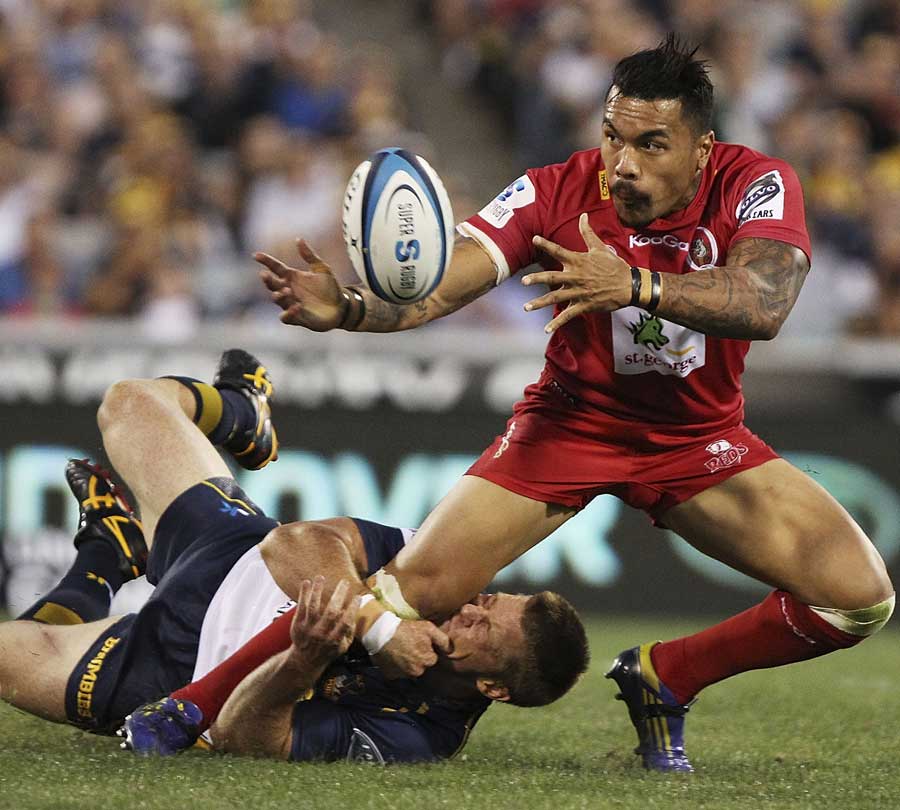 Reds winger Digby Ioane is tackled by Clyde Rathbone of the Brumbies