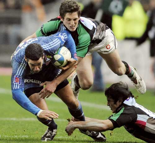 Stade Francais winger Julien Aria is tackled by the Harlequins defence 