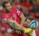 The Reds' Quade Cooper offloads under pressure from Dane Coles