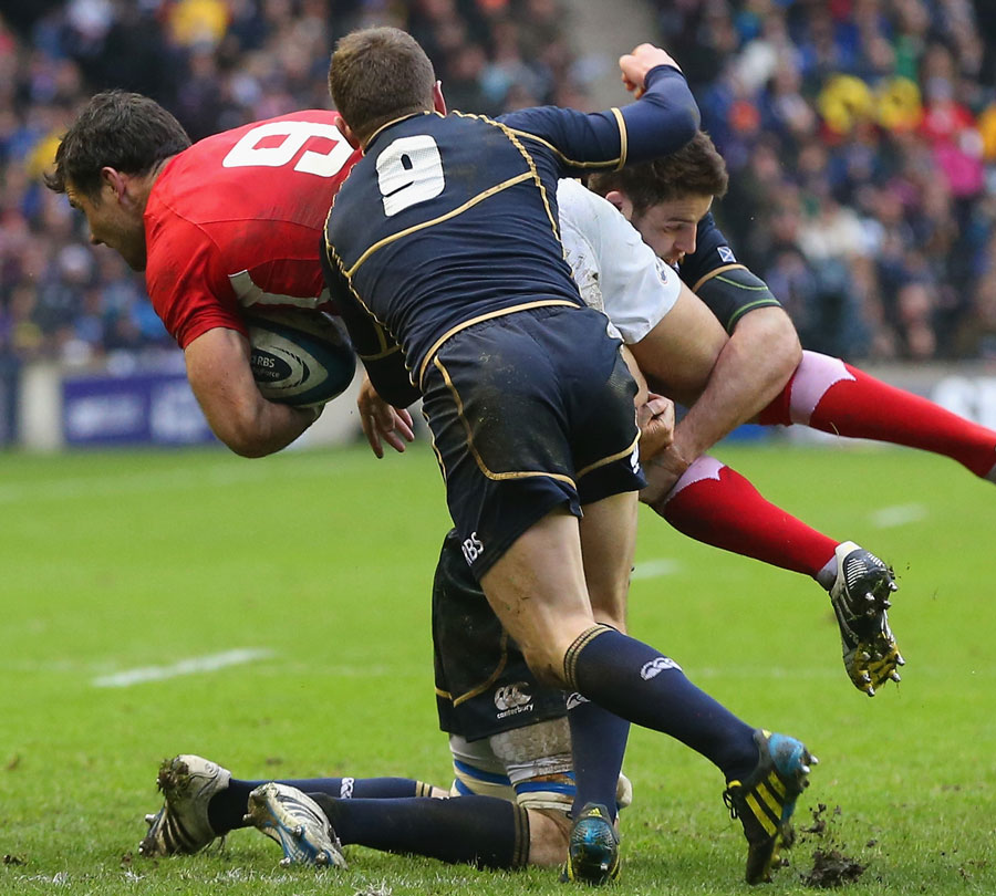 Wales' Mike Phillips is caught by Scotland's Greig Laidlaw and Johnnie Beattie