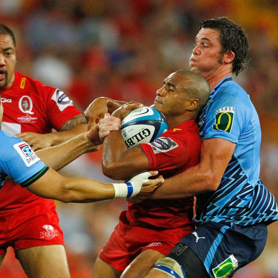 The Reds' Will Genia is tackled by Bulls players