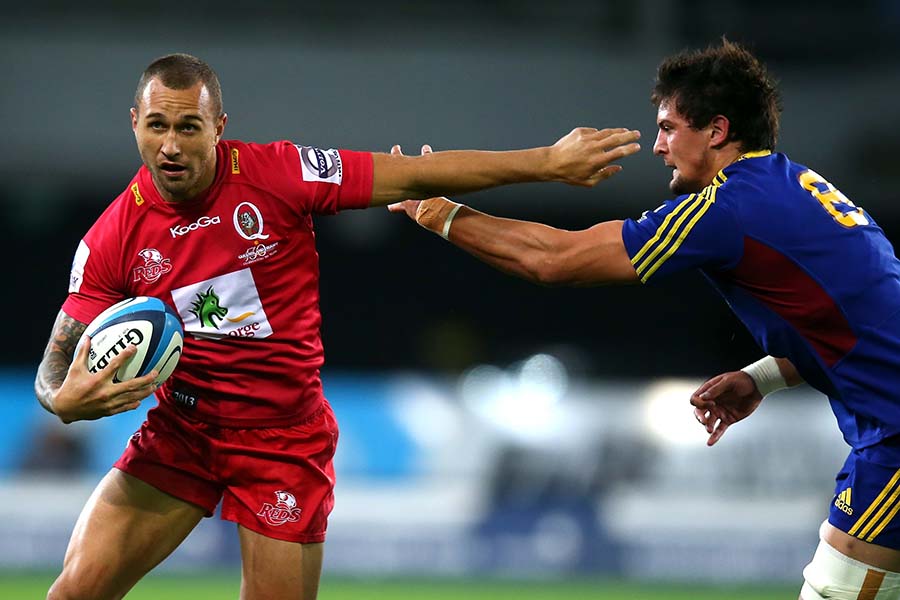 The Reds' Quade Cooper beats the tackle of the Highlanders' Elliot Dixon