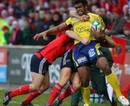 Clermont Auvergne's Napolioni Nalaga is tackled by Munster's Doug Howlett and Tomas O'Leary 