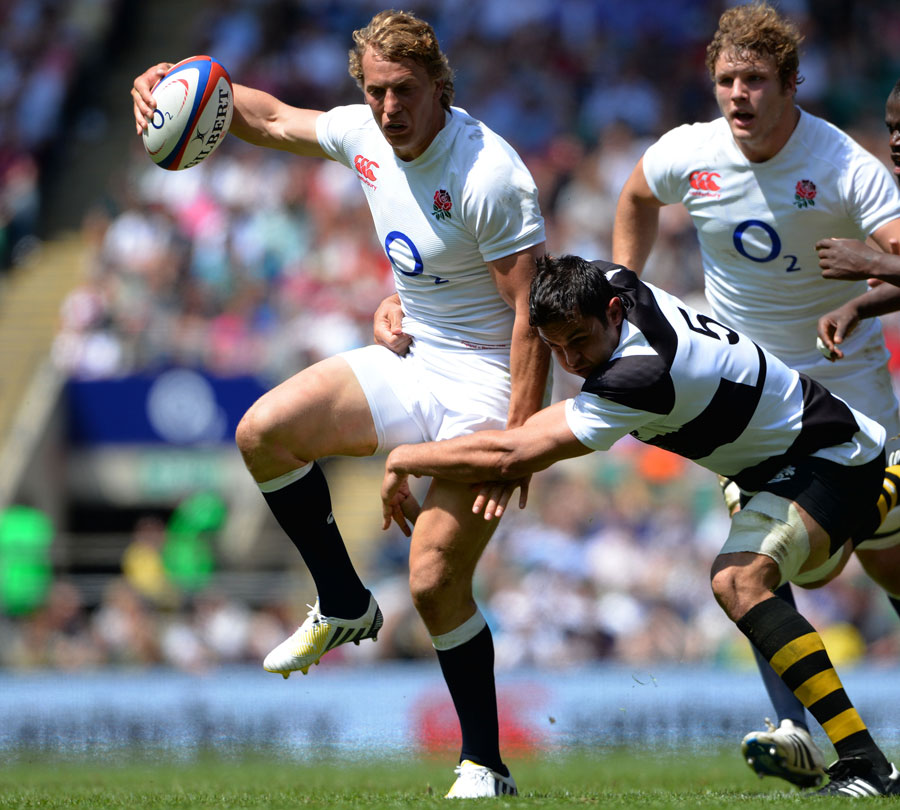 England's Billy Twelvetrees evades a tackle