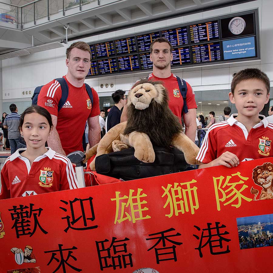 Stuart Hogg poses with a Lions team-mate and welcoming children
