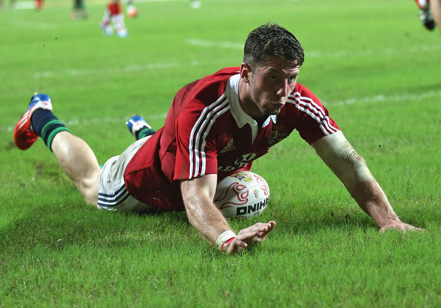 The Lions' Alex Cuthbert dives over to score