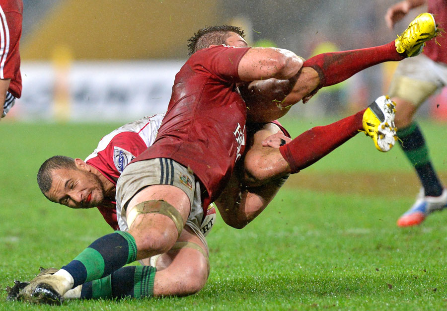 The Lions' Dan Lydiate tackles the Reds' Quade Cooper