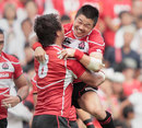 Japan's Fumiaki Tanaka and Takashi Kikutani celebrate victory over Wales