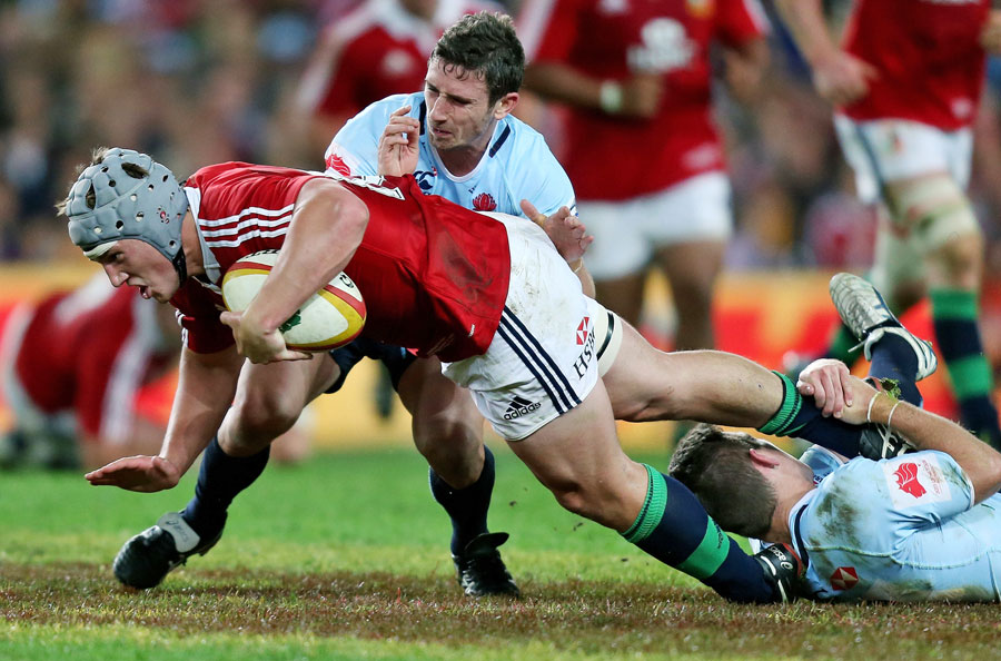 The Lions' Jonathan Davies is hauled down by the Waratahs' defence
