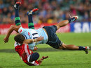 The Waratahs' Peter Betham tackles the Lions' Leigh Halfpenny
