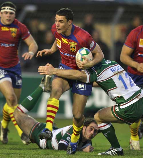 Perpignan's Dan Carter is tackled by Leicester's Aaron Mauger
