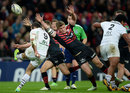 Owen Farrell attempts to charge down a kick by Jean-Marc Doussain