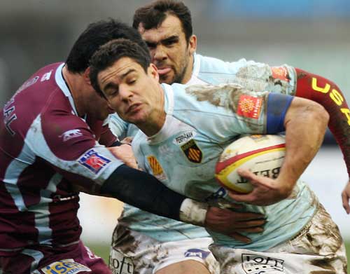 Perpignan's fly-half Dan Carter is tackled by Bourgoin's lock Coenie Basson 