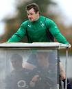 Ireland's Cian Healy arrives for training on a golf buggy driven by team-mate Jamie Heaslip