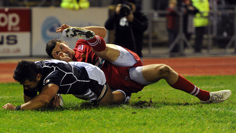 Toshiaki Hirose of Japan goes over for a try under pressure from Vasily Artemyev of Russia